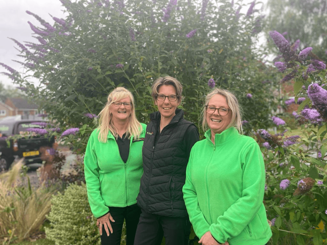 Three people posing in a garden
